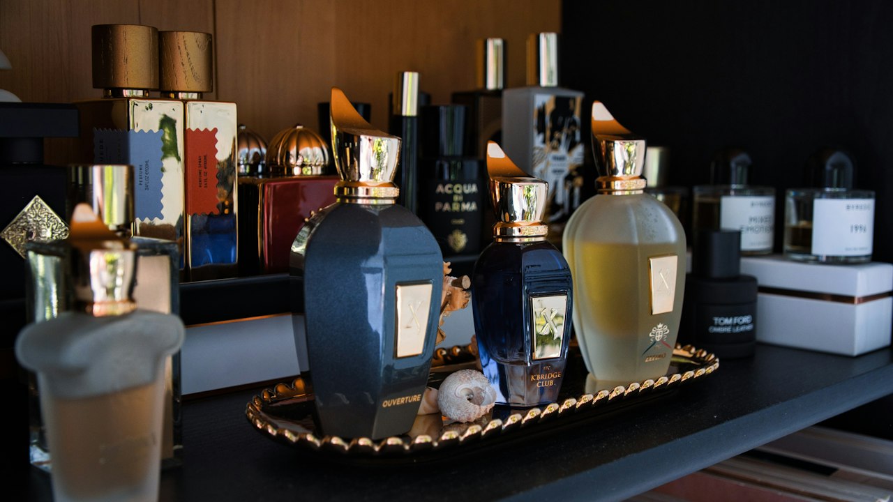 Premium fragrance and beauty bottles arranged on a marble retail counter